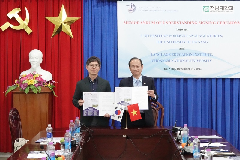 Men holding papers in front of a podiumDescription automatically generated