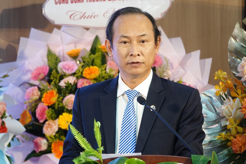 A person in a suit and tie standing at a podiumDescription automatically generated